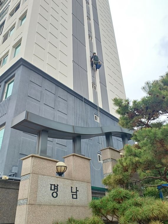 상층부 외벽 작업. 아래는 건물 출입구.